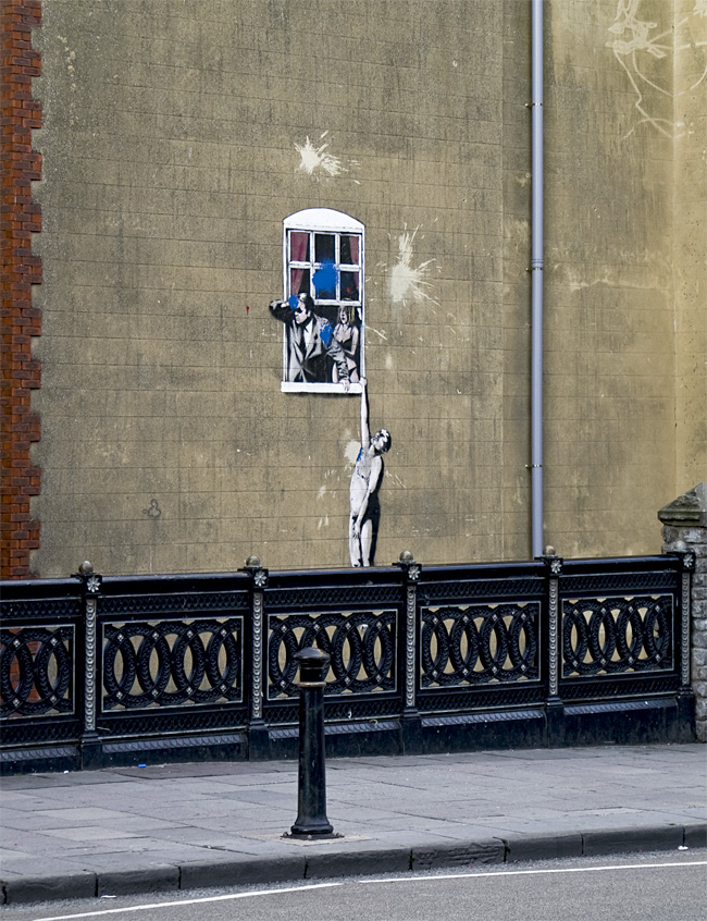 naked man hanging out of a bedroom window